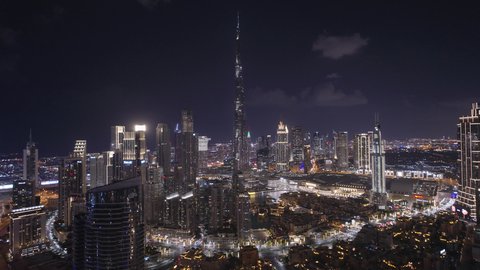 حركة مرور السيارات في الشوارع والطرقات، النمو والتقدم والتوسع العمراني، تصوير درون جوي  للأبراج وناطحات السحاب المضيئة ليلا في مدينة دبي، الفن الهندسي المعماري للمباني والمنشآت في الإمارات العربية المتحدة