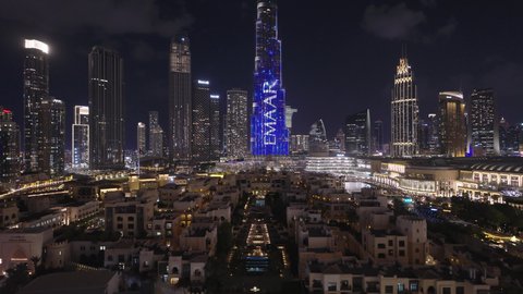 حركة مرور السيارات في الشوارع والطرقات، النمو والتقدم والتوسع العمراني، تصوير درون جوي  للأبراج وناطحات السحاب المضيئة ليلا في مدينة دبي، الفن الهندسي المعماري للمباني والمنشآت في الإمارات العربية المتحدة