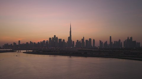 حركة مرور السيارات في الشوارع والطرقات، النمو والتقدم والتوسع العمراني، تصوير درون جوي  للأبراج وناطحات السحاب المضيئة ليلا في مدينة دبي، الفن الهندسي المعماري للمباني والمنشآت في الإمارات العربية المتحدة