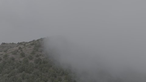Foggy and cloudy skies in high areas, famous natural tourist attractions in the city of Abha, terrain in mountain peaks and heights, aerial drone photography of the Al-Souda Mountains in the Asir region in the Kingdom of Saudi Arabia, slopes and rugged rocky roads