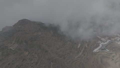 Foggy and cloudy skies in high areas, famous natural tourist attractions in the city of Abha, terrain in mountain peaks and heights, aerial drone photography of the Al-Souda Mountains in the Asir region in the Kingdom of Saudi Arabia, slopes and rugged rocky roads