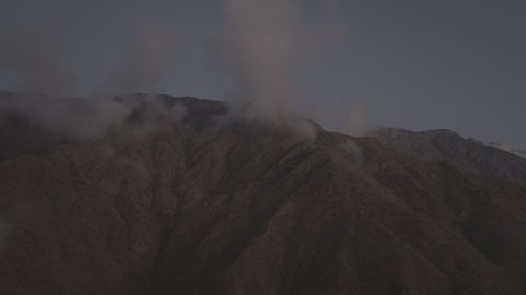 Foggy and cloudy skies in high areas, famous natural tourist attractions in the city of Abha, terrain in mountain peaks and heights, aerial drone photography of the Al-Souda Mountains in the Asir region in the Kingdom of Saudi Arabia, slopes and rugged rocky roads