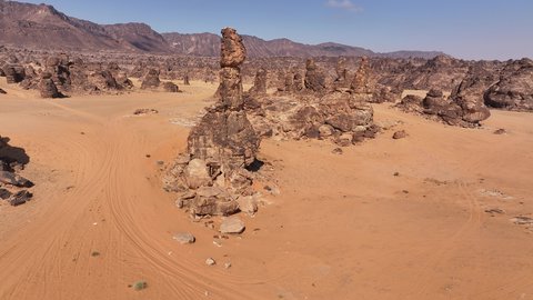 Ancient historical archaeological site, terrain, peaks and mountain heights in the desert, drone footage of a Saudi Arabian Gulf man wearing traditional thobe and shemagh standing on Mount Aja in Hail city, mountains and rock formations in desert areas of Saudi Arabia, natural water pool
