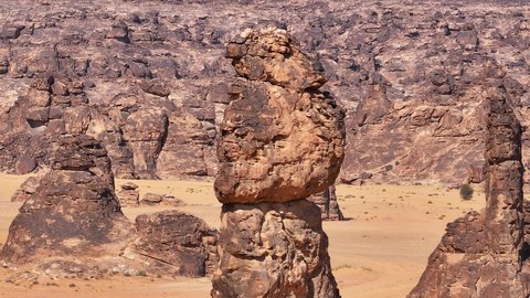 Ancient historical archaeological site, terrain, peaks and mountain heights in the desert, drone footage of a Saudi Arabian Gulf man wearing traditional thobe and shemagh standing on Mount Aja in Hail city, mountains and rock formations in desert areas of Saudi Arabia, natural water pool