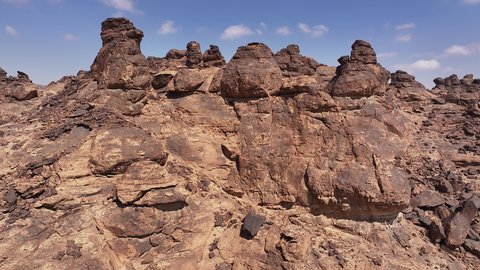 Ancient historical archaeological site, terrain, peaks and mountain heights in the desert, drone footage of a Saudi Arabian Gulf man wearing traditional thobe and shemagh standing on Mount Aja in Hail city, mountains and rock formations in desert areas of Saudi Arabia, natural water pool