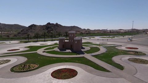 Traffic movement on the roads and streets of the Kingdom of Saudi Arabia, aerial drone photography of the castle roundabout in Hail, famous tourist attractions, trees and green plants surrounding Saudi regions and cities