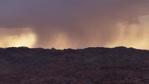 هطول الامطار فوق الجبال والتكوينات الصخرية في المناطق الصحراوية في المملكة العربية السعودية، مكان أثري تاريخي قديم، التضاريس والقمم والمرتفعات الجبلية في الصحراء، فصل الشتاء في مدينة حائل