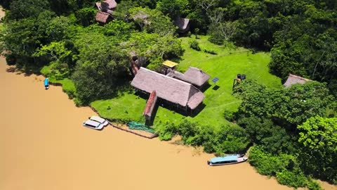 نُزُل بيئي مُختبئ في غابة الأمازون بجوار نهر مُوحل | لقطات جوية من طائرة بدون طيار