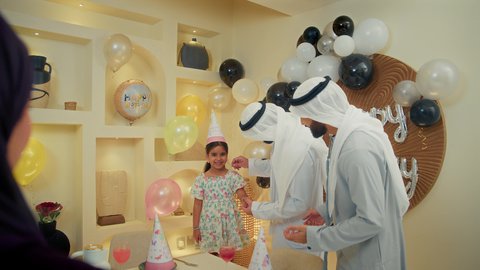 أعياد ومناسبات عائلية سعيدة، ايماءات وجه تدل على الإستمتاع والفرح، امفهوم الألفة والمحبة الأسرية، تصوير مقرب لعائله عربيه خليجيه اماراتية ترتدي الثوب التقليدي تحتفل بعيد الميلاد مع  طفتلهم