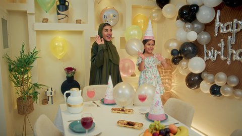 تقديم الهدايا والمفاجآت للأطفال، تعليق الزينة والبالونات الملونة، اعياد ومناسبات سعيدة، اب عربي خليجي يقوم بحمل طغلته للاعلي بايماءات السعادة و السرور، عائله عربيه خليجيه اماراتية تقوم بالاحتفال بعيد ميلاد ابنتهم