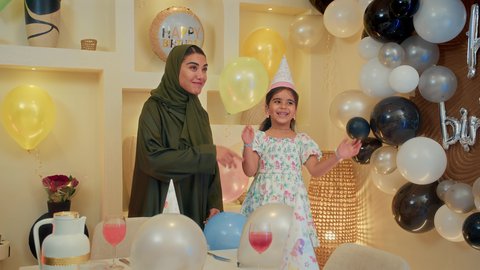 مشاركة لأجواء رائعة عائلية داخل المنزل، تعليق الزينة والبالونات الملونة، اعياد ومناسبات سعيدة، اب عربي خليجي يقوم بحمل طغلته للاعلي بايماءات السعادة و السرور، عائله عربيه خليجيه اماراتية تقوم بالاحتفال بعيد ميلاد ابنتهم