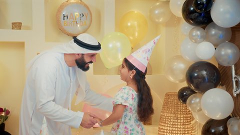 أجواء فرحة لأسرة اماراتية، اعياد ومناسبات سعيدة، مشاركة لأجواء رائعة عائلية داخل المنزل، ام عربية خليجيه تقوم بحمل طفلتها للاعلي بايماءات السعادة و السرور، عائله عربيه خليجيه اماراتية تقوم بالاحتفال بعيد ميلاد ابنتهم