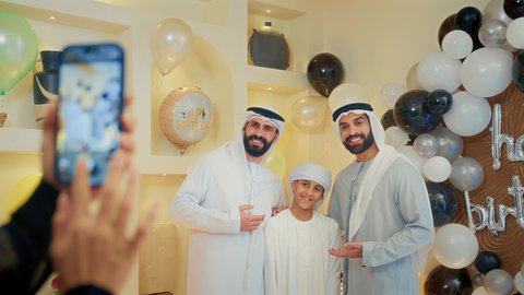 ايماءات البهجة والسرور، توثيق اللحظات السعيدة، زينة أعياد الميلاد و المناسبات، ،عائله عربيه خليجيه اماراتية تقوم بالاحتفال بعيد الميلاد  ، تصوير مقرب ليد امراه تقوم بالتقاط الصور التذكارية عبر الهاتف المحمول