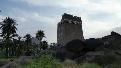 Focus on planting trees and green plants, attracting tourists from all over the world, famous tourist sites in the ancient city of Najran, historical monuments in the Kingdom of Saudi Arabia, aerial drone photography of a mud house in the old town.