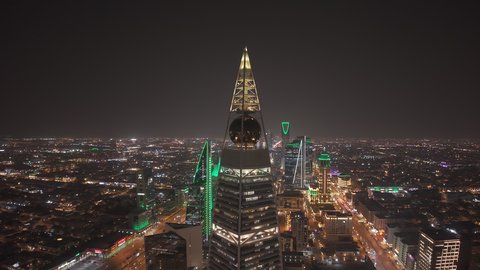 النهضة الاقتصادية والعمرانية لأفق العاصمة, معالم جذب سياحية مشهورة في المملكة العربية السعودية، الفن الهندسي المعماري للأبراج و ناطحات السحاب، تصوير درون مقرب مبنى برج الفيصلية في حي العليا في مدينة الرياض في الليل