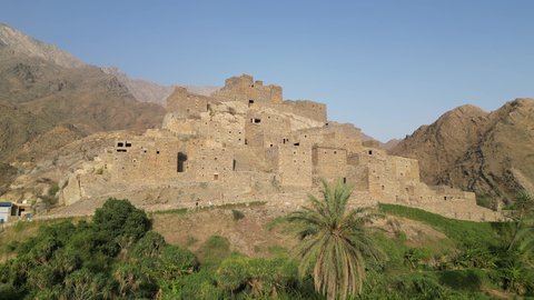 The Arabic architectural art of the old stone houses in Al Baha city, the mountain peaks and heights in the village of Dhi Ain, green trees and plants, a village on a white marble mountain, ancient historical monuments, tourist attractions in Saudi Arabia
