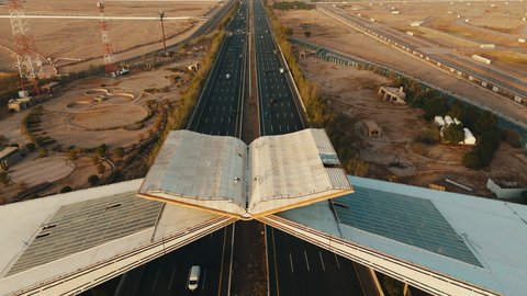 Sacred Islamic religious sites, roads prepared for travel and transportation between Jeddah and Mecca, aerial drone photography of a model of the Quran Gate in Mecca in the shape of the Holy Quran at sunset, traffic movement on paved roads in the Kingdom of Saudi Arabia