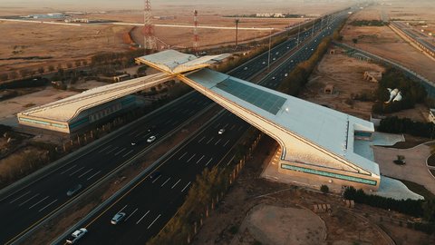 Traffic movement on paved roads in the Kingdom of Saudi Arabia, Islamic religious holy sites, roads prepared for travel and transportation between Jeddah and Mecca, aerial drone photography of a model of the Quran Gate in Mecca in the shape of the Holy Quran at sunset