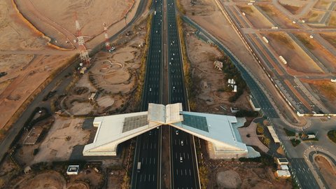 الحركة المرورية في الشوارع المعبدة في المملكة العربية السعودية, أماكن اسلامية دينية مقدسة, الطرقات المهيئة للسفر والتنقل بين جدة ومكة, تصوير درون جوي لمجسم بوابة القرآن في مكة المكرمة على شكل المصحف الشريف وقت غروب الشمس