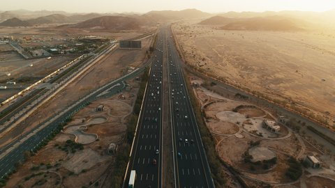 Traffic movement on paved roads in the Kingdom of Saudi Arabia, Islamic religious holy sites, roads prepared for travel and transportation between Jeddah and Mecca, aerial drone photography of a model of the Quran Gate in Mecca in the shape of the Holy Quran at sunset