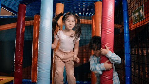 قضاء اوقات سعيدة ، القفز بداخل مركز العاب داخلي ،  تصوير لطفلان عربيان خليجيان إماراتيان برتديان الزى الكاجوال ،  يتجاوزان العوائق المطاطية ، يستكشفان المسارات المليئة بالتحديات، الأنشطة الرياضية الممتعة