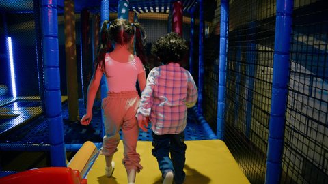 تصوير لطفلان عربيان خليجيان إماراتيان برتديان الزى الكاجوال ،  يتجاوزان العوائق المطاطية ، يستكشفان المسارات المليئة بالتحديات، الأنشطة الرياضية الممتعة ، مركز العاب داخلي ، قضاء اوقات سعيدة