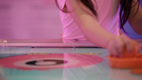 منافسة مليئة بالتحدي والإثارة ،نعابير الاندماج والتفاعل ،  قضاء الاوقات السعيدة ،الأنشطة الرياضية الممتعة ، تصوير مقرب ليد طفلة عربية خليجية إماراتية ترتدي الزى الكاجوال ، تستمتع بلعبة الهوكي الهوائي