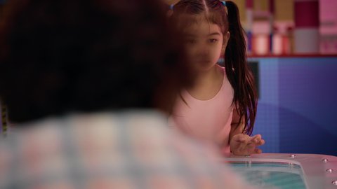 التفاعل بين أفراد العائلة، الأنشطة الرياضية الممتعة ، ايماءات الفوز والانتصار ،منافسة مليئة بالتحدي والإثارة ،  تصوير لطفلان اشقاء عربيان خليجيان إماراتيان يرتديان الزى الكاجوال ، يستمتعان بلعبة الهوكي الهوائي