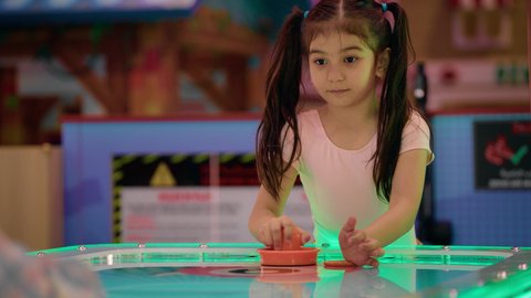 الأنشطة الرياضية الممتعة ، ايماءات الفوز والانتصار ،منافسة مليئة بالتحدي والإثارة ، التفاعل بين أفراد العائلة، تصوير لطفلان اشقاء عربيان خليجيان إماراتيان يرتديان الزى الكاجوال ، يستمتعان بلعبة الهوكي الهوائي