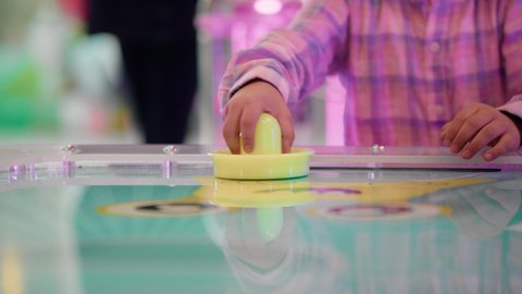 منافسة مليئة بالتحدي والإثارة ،ايماءات الاندماج والتفاعل ، قضاء الاوقات السعيدة ، الأنشطة الرياضية الممتعة ، تصوير لطفل عربي خليجي إماراتي يرتدي الزى الكاجوال ، يستمتع بلعبة الهوكي الهوائي