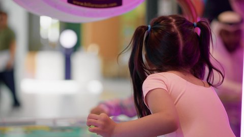 ايماءات المرح والحماس ،منافسة مليئة بالتحدي والإثارة ، التفاعل بين أفراد العائلة، تصوير لطفلان اشقاء عربيان خليجيان إماراتيان يرتديان الزى الكاجوال ، يستمتعان بلعبة الهوكي الهوائي، الأنشطة الرياضية الممتعة