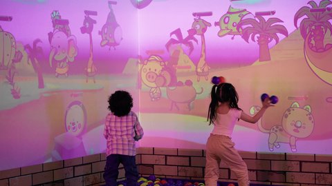 التفاعل بين أفراد العائلة ، تصوير لطفلان اشقاء عربيان خليجيان إماراتيان يرتديان الزى الكاجوال ، يستمتعان بلعبة الرمي التفاعلية ،أجواء المرح والحماس ، الأنشطة الرياضية الممتعة، منافسة مليئة بالتحدي والإثارة