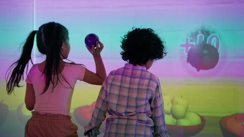 منافسة مليئة بالتحدي والإثارة ، التفاعل بين أفراد العائلة ، الأنشطة الرياضية الممتعة، أجواء المرح والحماس ، تصوير لطفلان اشقاء عربيان خليجيان إماراتيان يرتديان الزى الكاجوال ، يستمتعان بلعبة الرمي التفاعلية