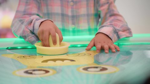 التفاعل بين أفراد العائلة، منافسة مليئة بالتحدي والإثارة ، أجواء مليئة بالمرح والحماس ،تصوير مقرب ليد طفلان اشقاء عربيان خليجيان إماراتيان يرتديان الزى الكاجوال ، يستمتعان بلعبة الهوكي الهوائي، الأنشطة الرياضية الممتعة