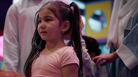 Having a great time, an atmosphere full of fun and enthusiasm, a competition full of challenge and excitement, a photo of two Emirati Gulf Arab siblings wearing casual clothes, enjoying an electronic basketball game