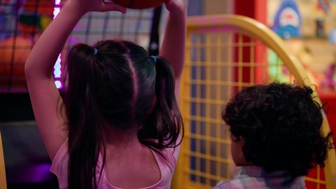 الأنشطة الرياضية الممتعة، أجواء مليئة بالمرح والحماس ، منافسة مليئة بالتحدي والإثارة ،تصوير لطفلان اشقاء عربيان خليجيان إماراتيان يرتديان الزى الكاجوال ، يستمتعان بلعبة كرة السلة الإلكترونية، التفاعل بين أفراد العائلة