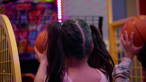 أجواء مليئة بالمرح والحماس ، منافسة مليئة بالتحدي والإثارة ،تصوير لطفلان اشقاء عربيان خليجيان إماراتيان يرتديان الزى الكاجوال ، يستمتعان بلعبة كرة السلة الإلكترونية، التفاعل بين أفراد العائلة، الأنشطة الرياضية الممتعة