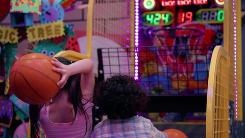 منافسة مليئة بالتحدي والإثارة ،تصوير لطفلان اشقاء عربيان خليجيان إماراتيان يرتديان الزى الكاجوال ، يستمتعان بلعبة كرة السلة الإلكترونية، التفاعل بين أفراد العائلة، الأنشطة الرياضية الممتعة، أجواء مليئة بالمرح والحماس