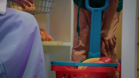 تنمية ودعم مهارات الأطفال، تعليم الابناء تسوق الخضار الطازجة من قسم البقالة، قضاء وقت ممتع في مركز الالعاب الترفيهيه، فتاة عربية خليجية سعودية ترتدي مئرز الطبخ، تصوير مقرب لسيدة عربية خليجية إماراتية تقوم بمشاركة ابنتها لحظات المرح، طعام صحي ومفيد