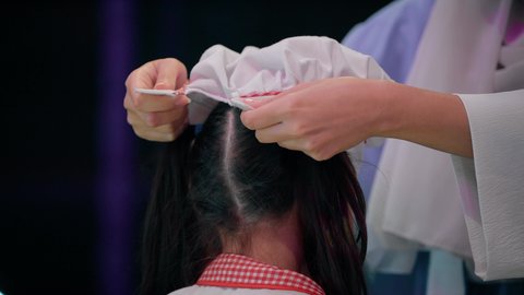 الاستعداد لدخول ركن الطبخ والطهي، قضاء وقت ممتع في مركز الالعاب الترفيهيه، وظائف ومهن مستقبلية، فتاة عربية خليجية سعودية ترتدي زي الطهاة، دعم وتنمية مهارات الطبخ عند الأطفال، تصوير مقرب لسيدة عربية خليجية إماراتية تقوم بمساعدة بنتها بارتداء زي الشيف الخاص