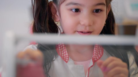 مهن ووظائف مستقبلية، دعم وتنمية مهارات الطبخ عند الأطفال، شغف البنات في المطبخ والطهي، الاستمتاع في اللعب في مركز الالعاب الترفيهيه، تصوير مقرب لفتاة عربية خليجية إماراتية ترتدي زي الشيف الخاص تقف أمام طاولة عليها مجموعة من ادوات الطبخ