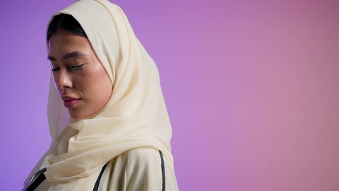 مفهوم الموضة والأناقة والاهتمام بالمظهر الخارجي، بورترية مقرب لشابتان عربيتان خليجتان سعوديتان محجبتان مبتسمتان ترتديان العباءة الملونه تنظران إلى الكاميرا بإيماءات السرور والثقة بالنفس ، النعومة والشياكة والأنوثة ،عباءات خليجية نسائية عصرية، صديقتان اماراتيان يقومان بقضاء أوقات ممتعة ، خلفية ملونه