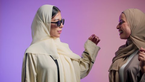 ايماءات يدين عل شكل قلب، بورتريه لسيدتان عربيتان خليجيتان اماراتيان مبتسمتان، المشاركة الايجابية والعلاقات اجتماعية، تعارف وصداقات مبنية على الحب والمودة، المحبة والترابط بين الأصدقاء، ارتداء العباءة الخليجية والنظارات الشمسية، خلفية ملونة