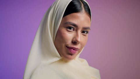 الاهتمام بالأناقة والمظهر الخارجي، مفهوم العناية بالجمال والإطلالة المتميزة، بورترية مقرب لسيدة عربية خليجية اماراتية محجبة تقوم بوضع النضارة الشمسية، سيدة سعودية تقوم بالتزين بالحلي والاكسسوارات خبيرة مستحضرات تجميلية، خلفية ملونه