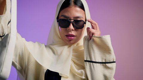 عرض موديلات حقائب عالمية فاخرة، أزياء واكسسوارات نسائيه ، سيدة اماراتية ترتدي العباءة الخليجية العصرية ونظارة شمسية سوداء، مفهوم الموضة والأناقة، تصوير مقرب لشابة عربية سعودية خليجية محجبة تحمل بيدها حقيبة بإيماءات السعادة