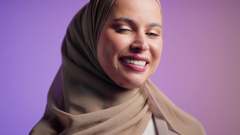 مفهوم الموضة والأناقة، أزياء واكسسوارات نسائيه ، تصوير مقرب لشابة عربية سعودية خليجية محجبة تنظر الى الكاميرا بإيماءات السعادة ، سيدة اماراتية ترتدي العباءة الخليجية العصرية