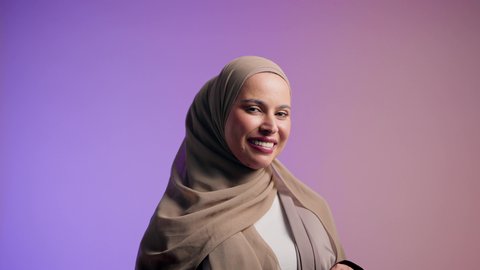 أزياء واكسسوارات نسائيه ، مفهوم الموضة والأناقة، تصوير مقرب لشابة عربية سعودية خليجية محجبة تنظر الى الكاميرا بإيماءات السعادة ، سيدة اماراتية ترتدي العباءة الخليجية العصرية