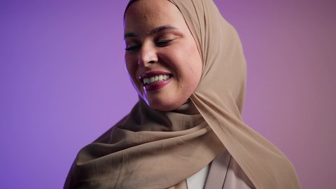 الاستمتاع بإمتلاك اكسسوارات عصرية, مفهوم الموضة والأناقة, تصوير لإمرأة عربية خليجية سعودية محجبة تقوم بتجربة النظارات الشمسية الجديدة, إيماءات الانوثة والجمال, سيدة اماراتية ترتدي عباءة أنيقة ونظارة سوداء معاصرة, خلفية ملونة