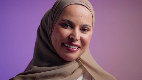 سيدة اماراتية ترتدي العباءة الخليجية العصرية ، مفهوم الموضة والأناقة، تصوير مقرب لشابة عربية سعودية خليجية محجبة تحمل بيدها حقيبة بإيماءات السعادة، عرض موديلات حقائب عالمية فاخرة، أزياء واكسسوارات نسائيه