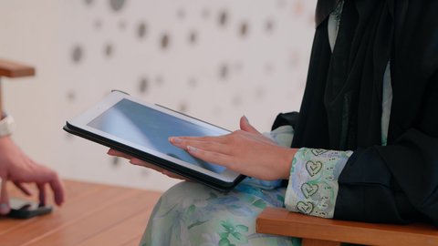 العمل عن بعد في الخارج، ادارة الأعمال وانجاز المهام المطلوبة عبر الجهاز اللوحي، مهنة ووظيفة نسائية، تصوير مقرب لإمرأة عربية خليجية اماراتية تستخدم جهاز التابليت المحمول، استخدام جهاز تقني حديث ومتطور